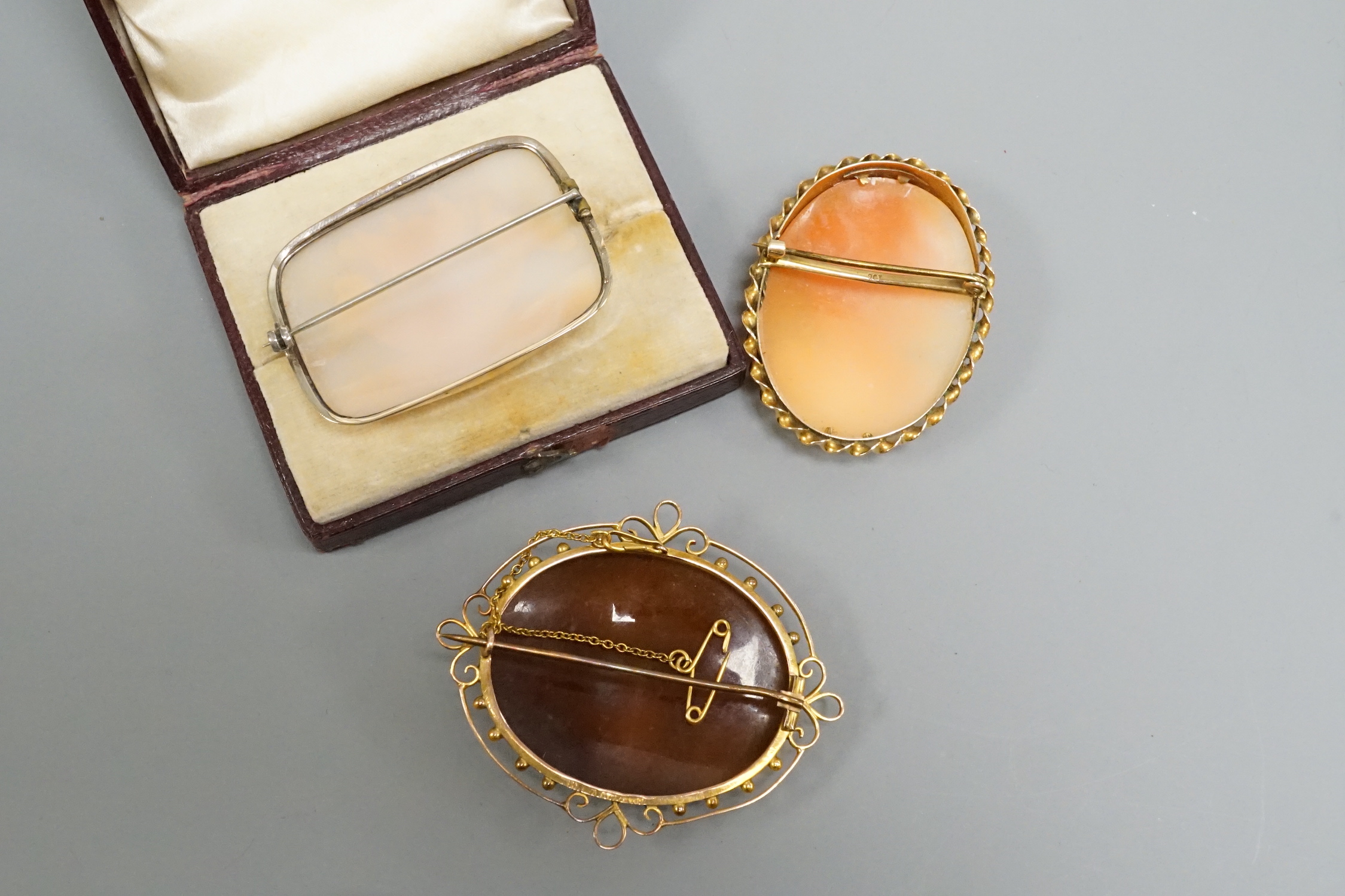 An early 20th century 9ct mounted oval cameo shell brooch, 57mm and two other cameo shell brooches including maiden and pliny doves.